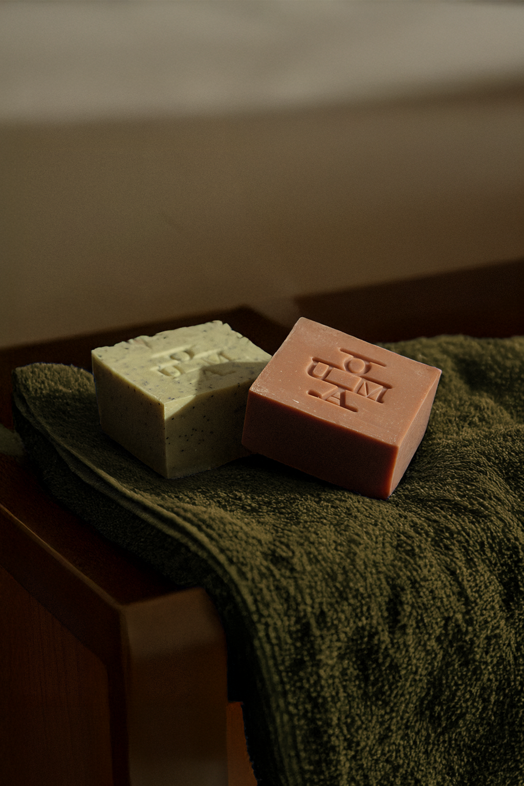 OUMA Soap bars on a green towel in a bathroom