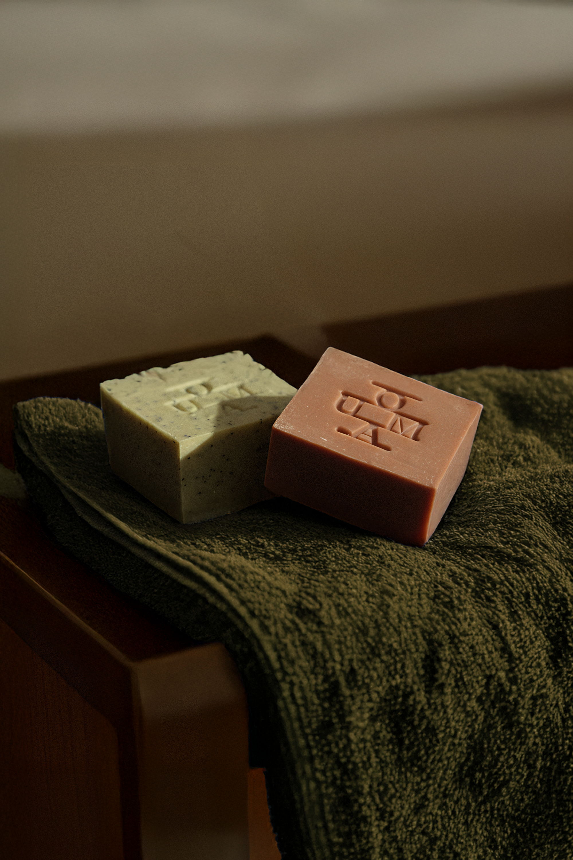 OUMA Soap bars on a green towel in a bathroom