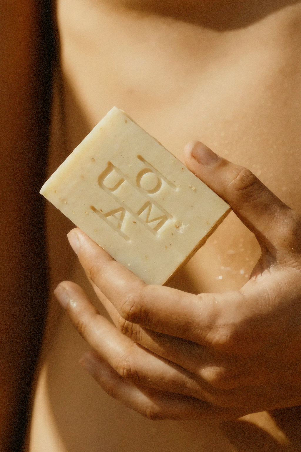 OUMA The Soap Bar Collection, No. 001 Grain Atmosphere image. Woman holding soap bar with hand.